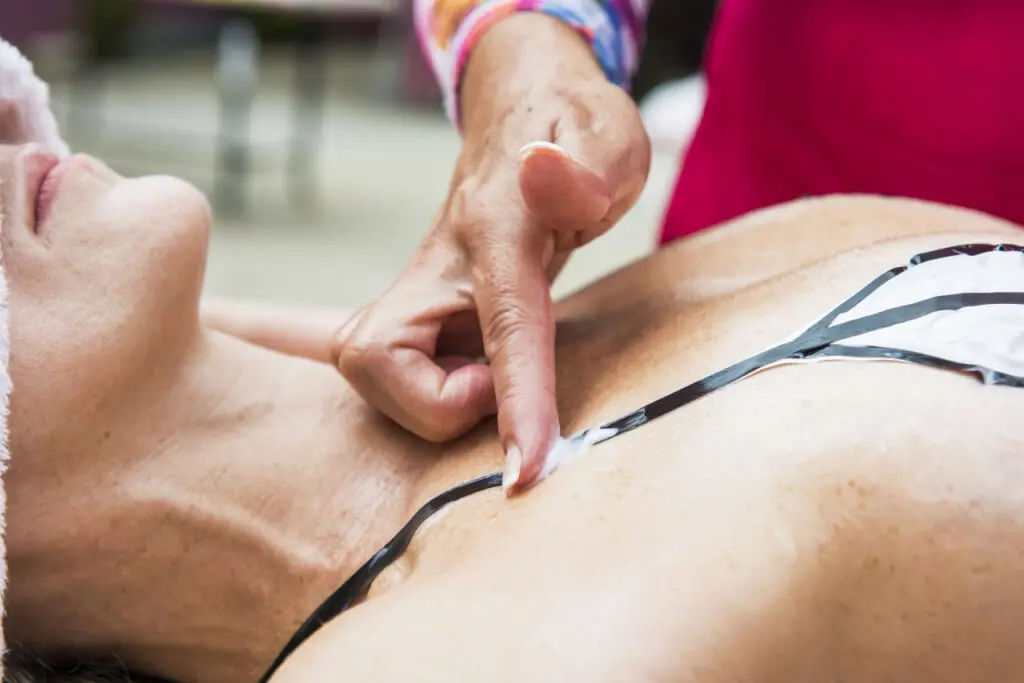 Profissional aplicando produto durante sessão de bronzeamento no Studio Bronze Jardim Guanabara.